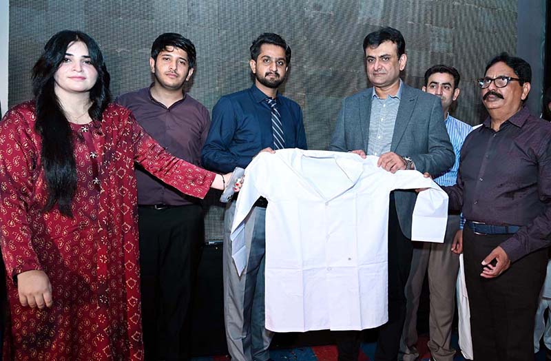 Deputy Commissioner Tariq Manzoor Chandio distributes ceremonial white coats to newly admitted DPT and BS Nursing students during the Orientation and White Coat Ceremony at Chandka Institute of Nursing and Allied Health Sciences