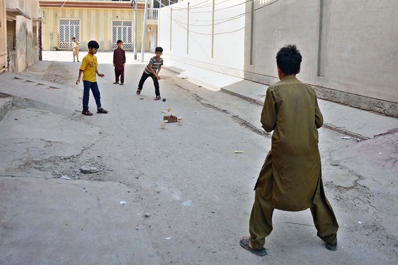 Children are playing the traditional game “Pittu Garam” in a street, enjoying outdoor recreation and preserving local cultural traditions