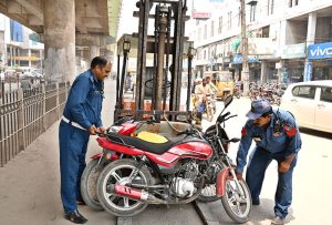 Traffic police officials are removing motorcycles wrongly parked in front of Trust Plaza.