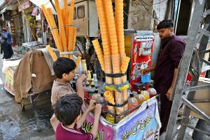 A vendor is selling ice cream to customers at his roadside setup in a local market.