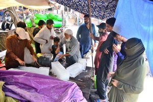 Residents purchase blocks of ice from a vendor at Bacha Khan Chowk as temperatures soar and demand for cooling essentials increases.