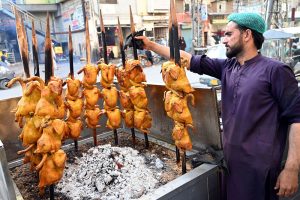 - A vendor tends to rows of whole chickens roasting on skewers over a charcoal grill at a roadside eatery, as the popular street food attracts hungry customers in the bustling city centre.