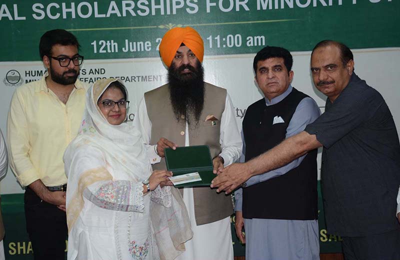 Provincial Minister for Minority Affairs Sardar Ramesh Singh Arora distributes educational scholarship cheques among students from minority communities during a ceremony held at the Divisional Model College (DMC) Hall