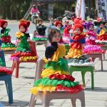 A vendor displays colorful handmade dolls at a roadside stall to attract the customers with vibrant designs and traditional decoration