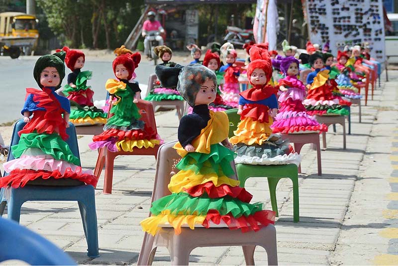 A vendor displays colorful handmade dolls at a roadside stall to attract the customers with vibrant designs and traditional decoration