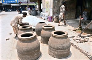 An artisan is busy preparing traditional oven (tandor) at Railway Road.