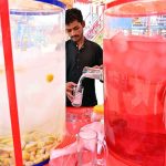 A vendor is preparing traditional summer drink (thadal) to attract the customers at Jinnah Bagh