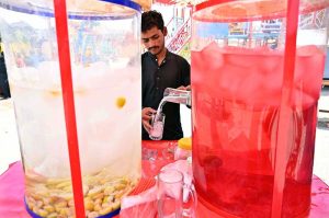A vendor is preparing traditional summer drink (thadal) to attract the customers at Jinnah Bagh