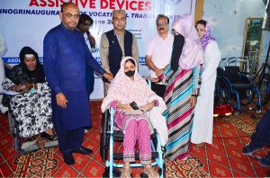 Regional Director DEPD Sindh Imtiaz Ahmad Sheikh and Pakistan Navy Commander Asif Raza present a wheelchair to a woman with disabilities during a wheelchair distribution ceremony at the Vocational Training Centre.