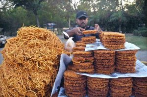 A vendor arranges traditional dal noodles and pakoras (dalpura) to attract customers at a roadside stall in the provincial capital.