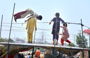 Gypsy children are enjoying jumping on a trampoline in the Latifabad area.