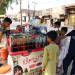 A young vendor prepares Ice Gola and Falooda for eager children at a roadside cart, as the beloved traditional cold treats see surging demand during the brutal summer heatwave