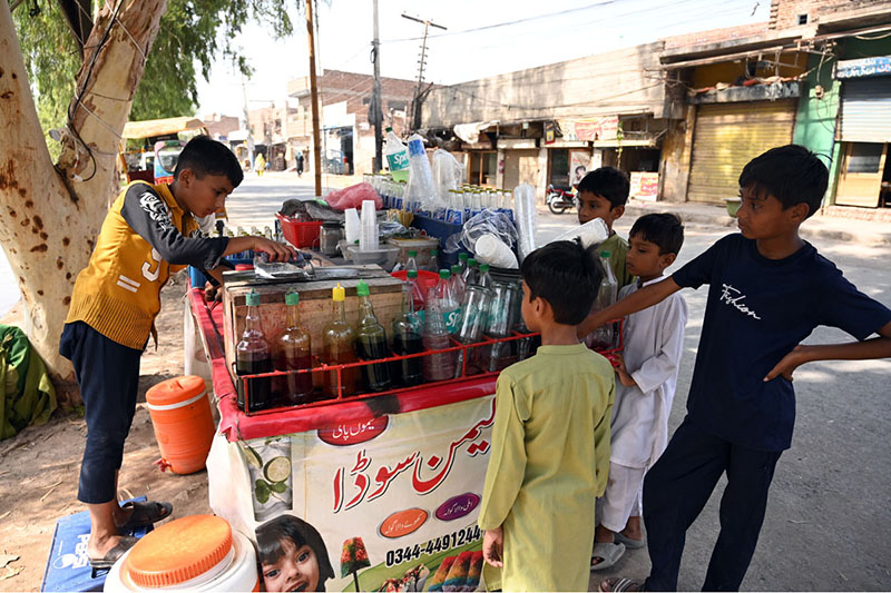 A young vendor prepares Ice Gola and Falooda for eager children at a roadside cart, as the beloved traditional cold treats see surging demand during the brutal summer heatwave