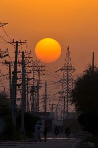 A memorizing view of sunset as golden hues of the setting sun illuminate the skyline and roadside structures create a captivating urban panorama.