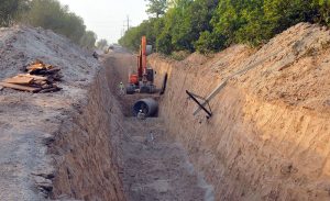 Labourers, assisted by heavy machinery, excavate a deep trench for the installation of a main sewerage pipeline on NLC Bypass Road as part of the city’s ongoing infrastructure development project.