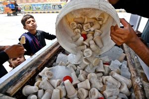 A vendor preparing traditional ice-cream (kulfi) on his pushcart.