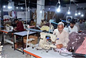 Workers are busy sewing clothes on machines at a local factory