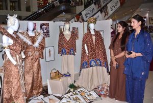 Government College Women University Faisalabad (GCWUF) Vice Chancellor Prof. Dr. Kanwal Ameen examines dresses designed by students during a visit to the 6th Fashion Design Thesis Display at Lyallpur Galleria, showcasing innovative designs, artistic expression, and the creativity of emerging fashion designers.