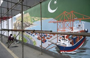An artist paints a mural on the walls of an underpass along Srinagar Highway as part of an urban beautification initiative in the federal capital.