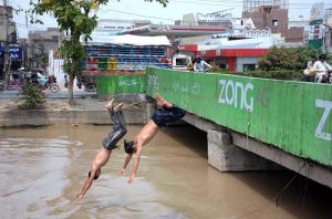 Youngster dive into a canal to cool off and seek relief from the intense heat as temperatures continue to soar in the city.