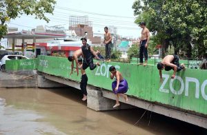 Youngster dive into a canal to cool off and seek relief from the intense heat as temperatures continue to soar in the city.