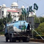 A Capital Development Authority (CDA) worker waters plants along a green belt near Parliament House to maintain the area's greenery and enhance the environment in the federal capital