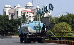 A Capital Development Authority (CDA) worker waters plants along a green belt near Parliament House to maintain the area's greenery and enhance the environment in the federal capital