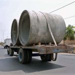 A tractor trolley passes through the old Shujabad road loaded with heavy concrete pipes
