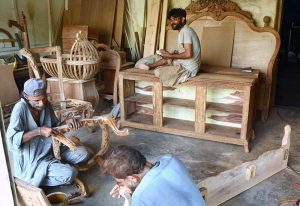 Carpenters are busy polishing wooden furniture at their workshop in the provincial capital.