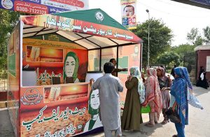 A Municipal Corporation worker distributes cold drinks to citizens at a heatwave relief camp established outside the DHQ Hospital.