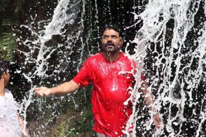 A man enjoy bathing to get relief from scorching hot weather in City.