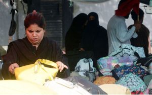 A woman selects used handbags at Empress Market