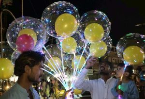 A man purchases balloons from a street hawker near Jinnah Bagh.