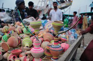 A craftsman selling traditional handmade clay toys for children at a village fair.
