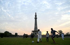 Youngsters playing football at Greater Iqbal Park as in the background an attractive view of sunrise in the Provincial Capital.