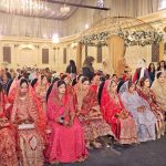 Brides are sitting on stage during a mass marriage ceremony arranged by the Madina Foundation to unite 35 deserving couples at a local marriage hall
