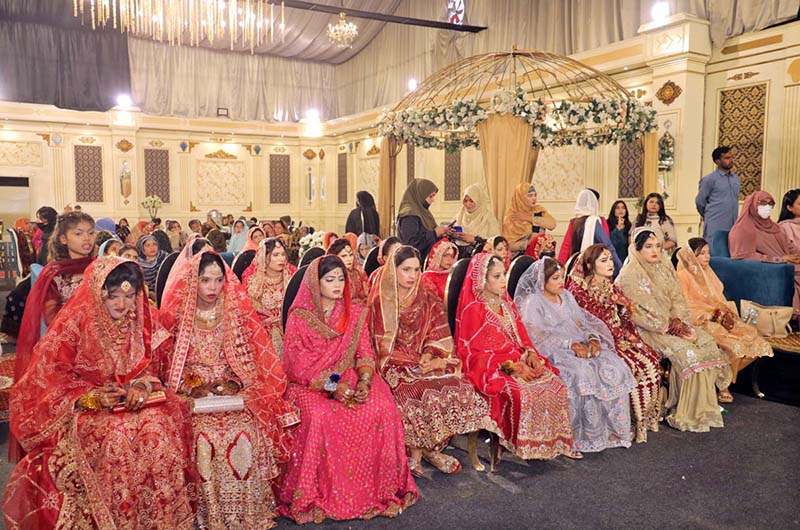 Brides are sitting on stage during a mass marriage ceremony arranged by the Madina Foundation to unite 35 deserving couples at a local marriage hall