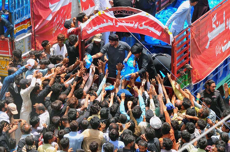 Volunteers distributing food packets and water among the mourners participates in the 9th Muharram-ul-Haram procession at Mumtazabad area. Muharramul Haram is known as the first month of the Islamic calendar and the mourning month in remembrance of the martyrdom (Shahadat) of Hazrat Imam Hussain (RA), the grandson of the Holy Prophet Mohammad (PBUH)