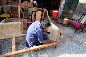Skilled craftsmen weave intricate cane webbing on elaborately carved wooden furniture at a traditional workshop, keeping alive the centuries-old craft of cane furniture making that provides livelihoods to hundreds of artisans across Country.