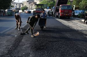 Labourer busy in repairing the road near Badami Bagh in the Provincial Capital.