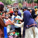 Volunteers serve summer drink to people during a hot day in the city, providing relief to passersby to escape the heat wave amid rising temperatures