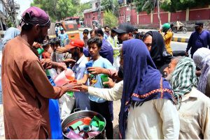 Volunteers serve summer drink to people during a hot day in the city, providing relief to passersby to escape the heat wave amid rising temperatures