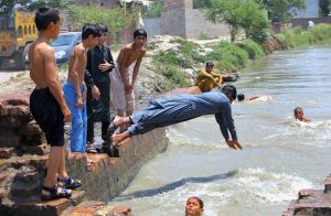 Youngsters dive into a canal along Ring Road to cool off and seek relief from the scorching summer heat in the provincial capital.
