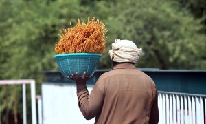 A street vendor carries salted vermicelli on his shoulder to sell to commuters along the busy Expressway in the federal capital.