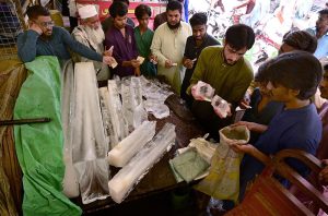 People enjoy lassi as a vendor serves the traditional yogurt-based drink to attract customers during hot weather in the city