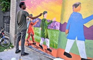 An artist is painting on the walls of the city.