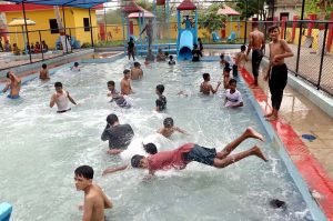 Youngsters enjoy swimming and diving at a water park to beat the scorching summer heat prevailing in the metropolis.