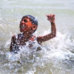 A youngster takes a bath in a canal to seek relief from the intense summer heat in the city