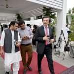 A parliamentarian waits for fellow lawmakers outside Parliament House ahead of the National Assembly budget session for the Federal Budget FY2026–27 in the federal capital
