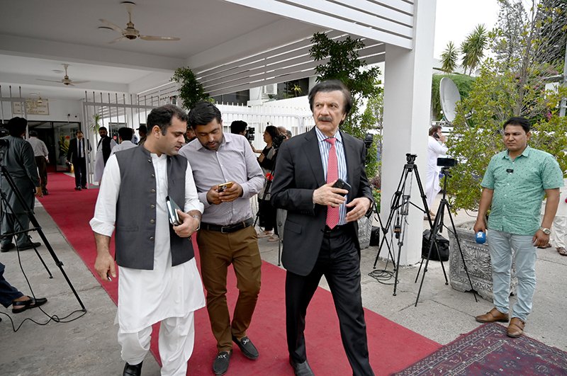 A parliamentarian waits for fellow lawmakers outside Parliament House ahead of the National Assembly budget session for the Federal Budget FY2026–27 in the federal capital